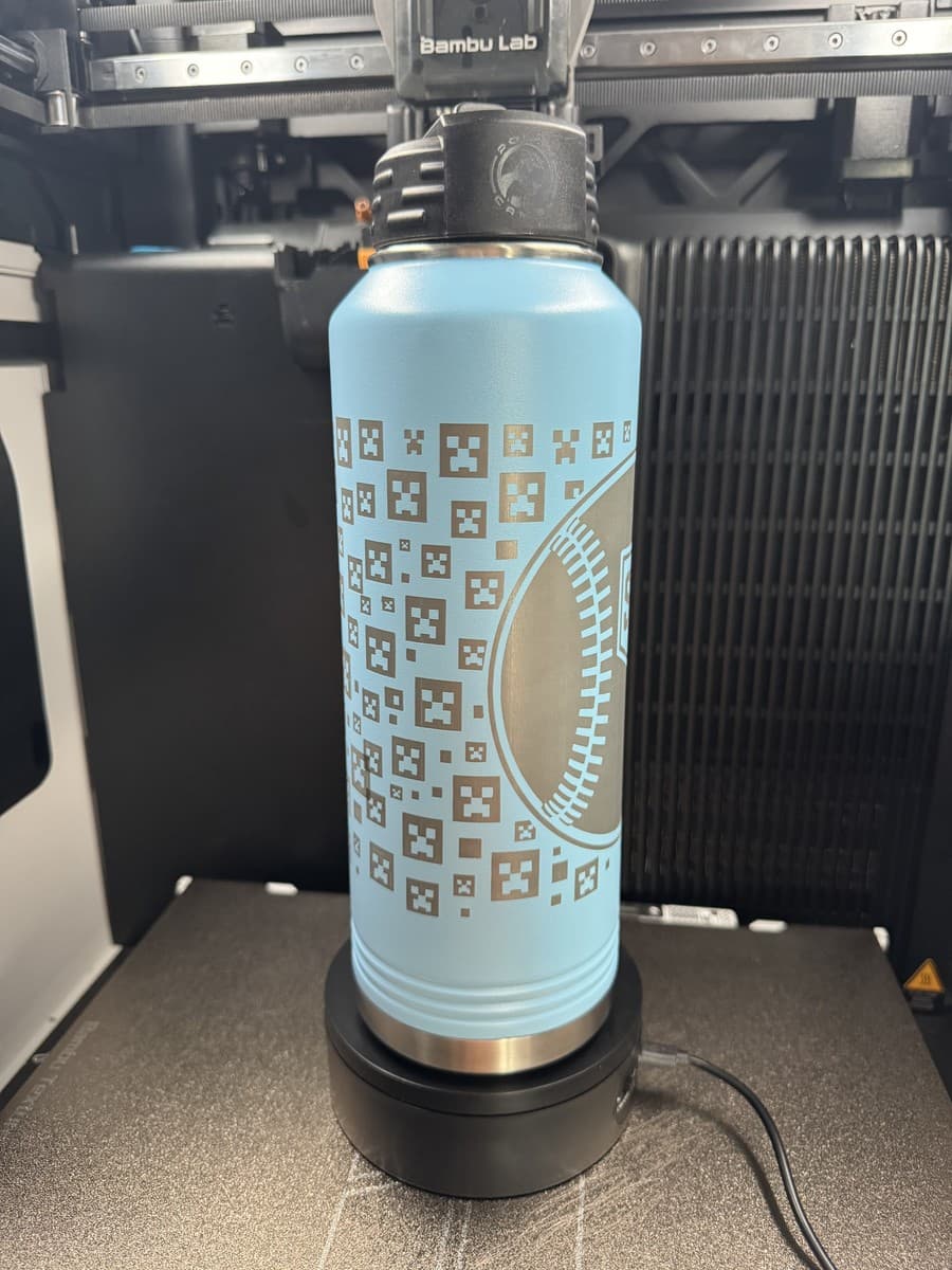 Alternate side of light-blue water bottle with repeating baseball symbols