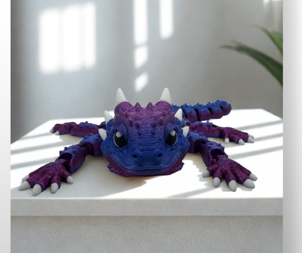 3D-printed articulated dragon figurine displayed on a stand
