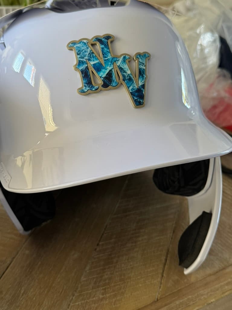 Blue patterned raised NV decal with a contrasting border attached to a white batting helmet
