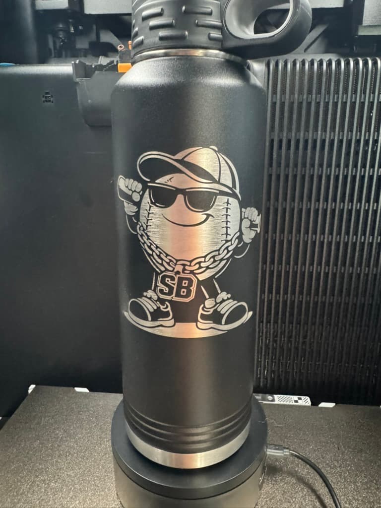 Detailed custom laser engraving on a black insulated bottle