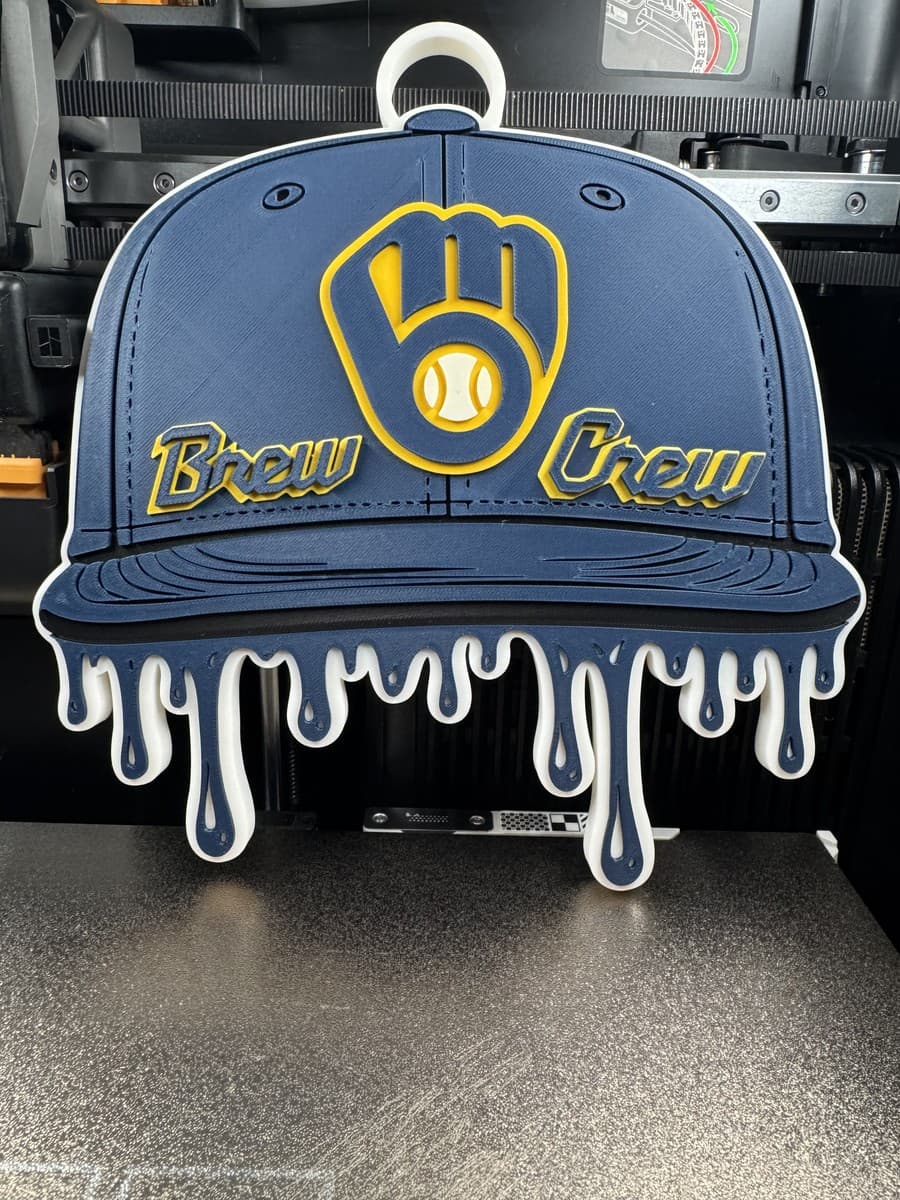Blue and yellow Brew Crew cap-shaped hype-chain pendant with drip detail