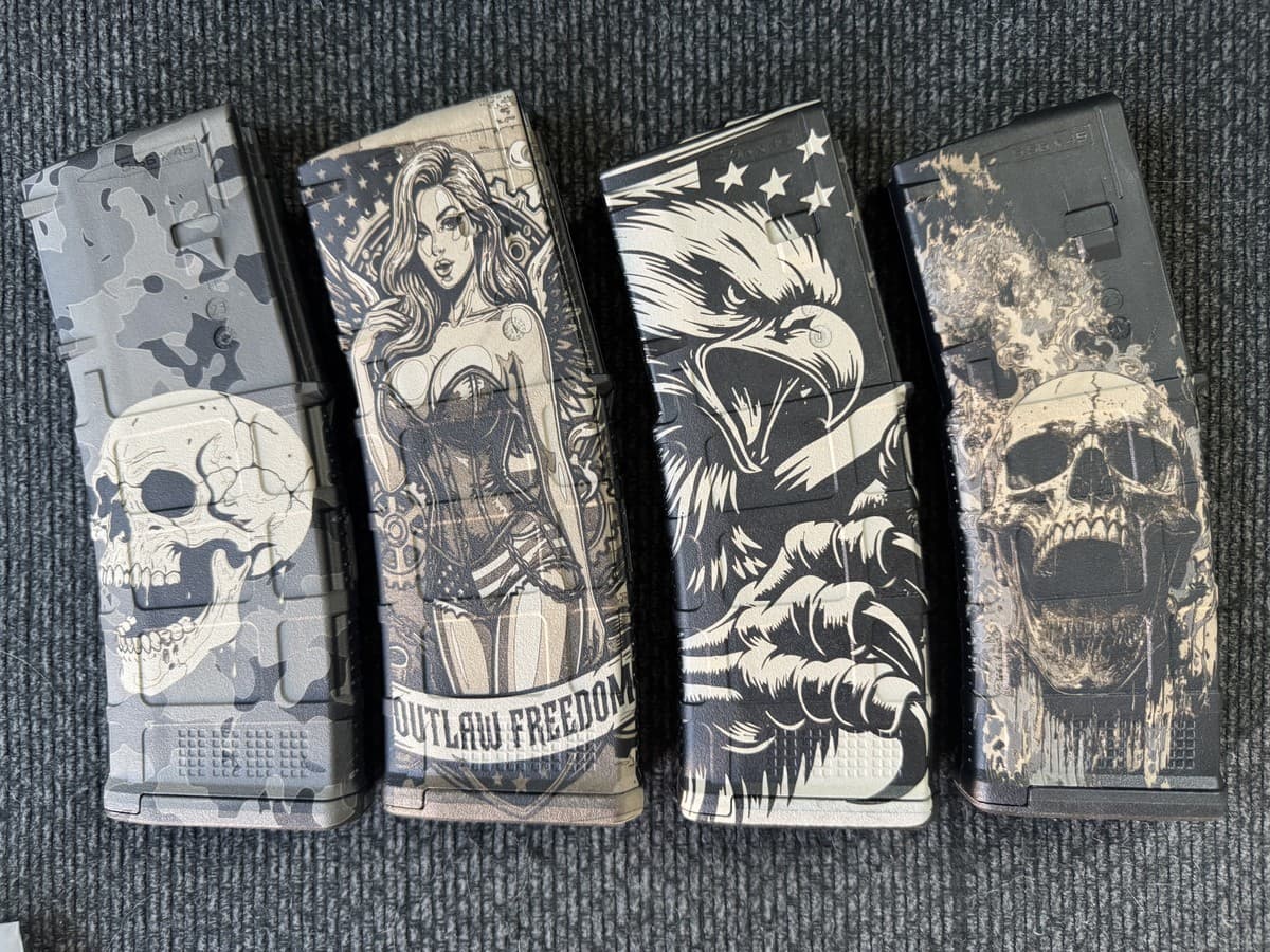 Four PMAG-style magazine bodies with engraved character, skull and eagle artwork