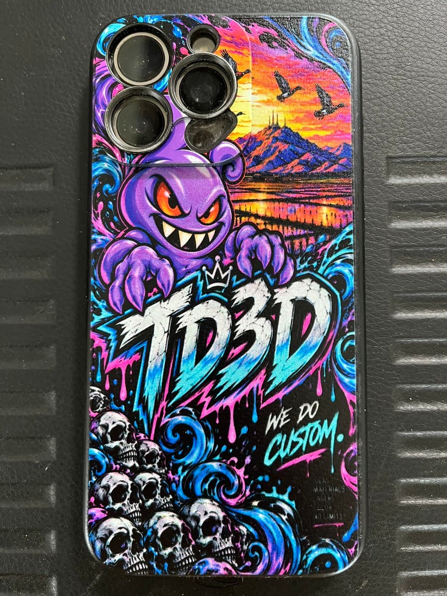 Completed TD3D phone case with full-color UV-printed purple character, TD3D lettering, cyan and pink artwork