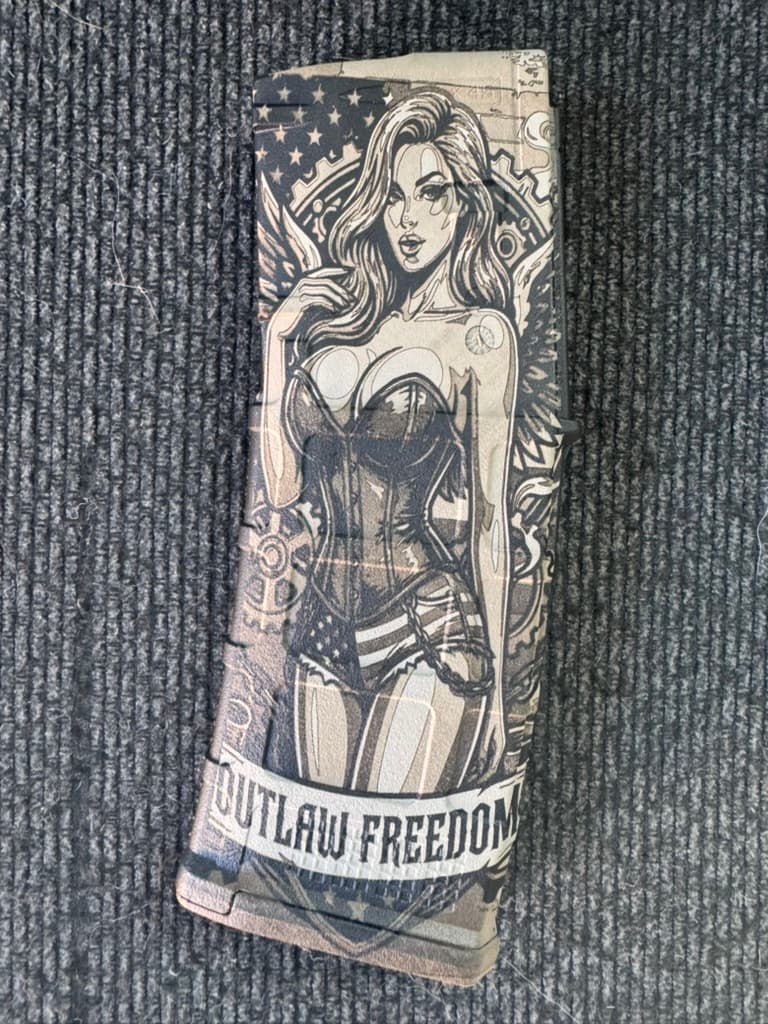 Close-up of a customer-owned PMAG with an Outlaw Freedom character engraving